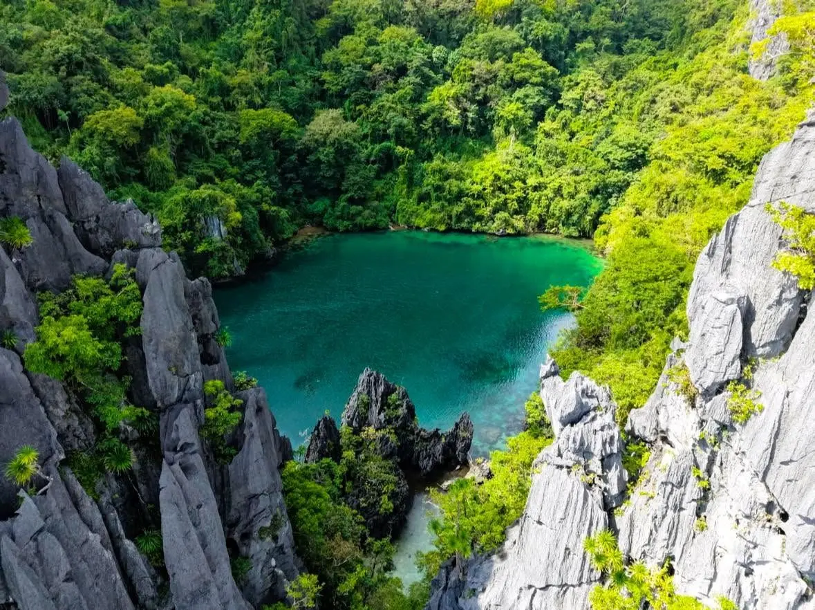 A hidden turquoise lagoon inside El Nido's limestone cliffs