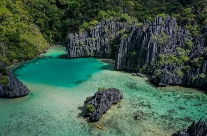 A turquoise lagoon framed by sharp grey limestone